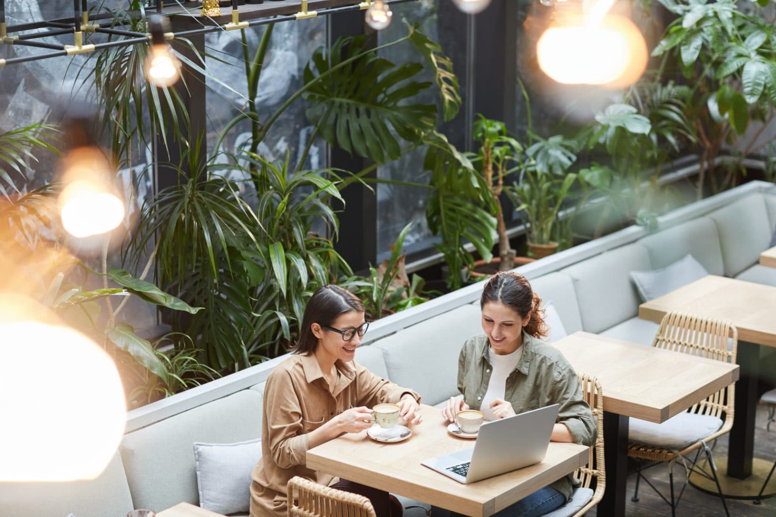 Two small-business owners working together on a laptop over coffee
